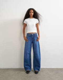 Model wearing Barrel mid rise jean in mid blue