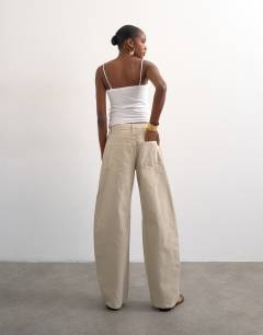 Model wearing Barrel mid rise jean in oat