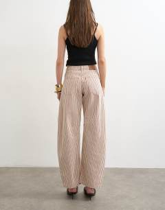 Model wearing Barrel mid rise jean in red stripe