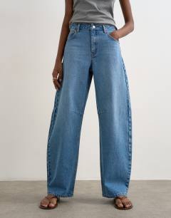 Model wearing Barrel mid rise jean in vintage blue