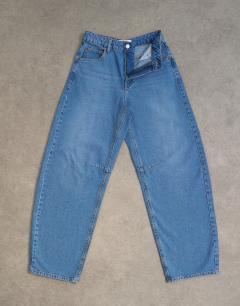 Model wearing Barrel mid rise jean in vintage blue