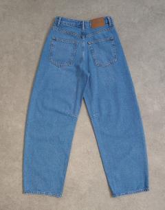 Model wearing Barrel mid rise jean in vintage blue
