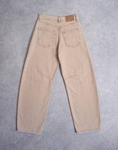 Model wearing Barrel mid rise jean in washed beige