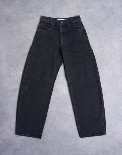 Model wearing Barrel mid rise jean in washed black 