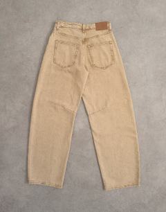 Model wearing Barrel mid rise jeans in washed beige