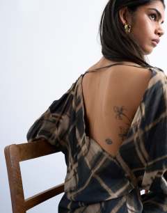 Model wearing Batwing backless mini dress in black blurred check