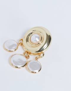 Model wearing Becca drop earrings in gold and pearl