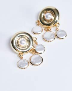 Model wearing Becca drop earrings in gold and pearl