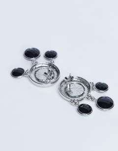 Model wearing Becca drop earrings in silver and black