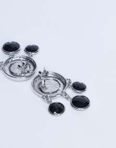 Model wearing Becca drop earrings in silver and black