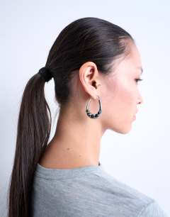 Model wearing Belle hoop earrings with black semi-precious stones in silver