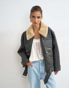 Model wearing Belted faux leather jacket in black and tan