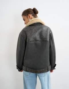 Model wearing Belted faux leather jacket in black and tan