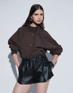 Model wearing Belted mini faux leather short in black