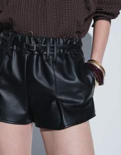Model wearing Belted mini faux leather short in black