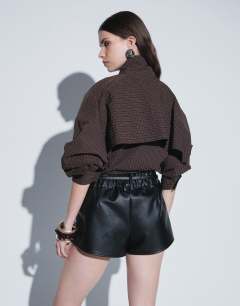 Model wearing Belted mini faux leather short in black