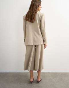 Model wearing Belted pleated cropped wide leg trouser in beige