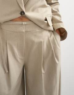 Model wearing Belted pleated cropped wide leg trouser in beige