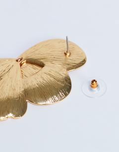 Model wearing Birdie stud statement earrings in gold
