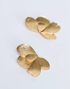 Model wearing Birdie stud statement earrings in gold