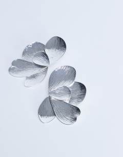 Model wearing Birdie stud statement earrings in silver