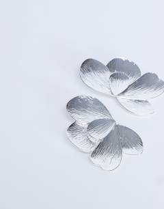 Model wearing Birdie stud statement earrings in silver