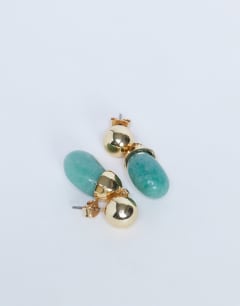 Model wearing Blaze stud earrings with drop design in gold and green