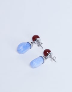 Model wearing Blaze stud earrings with drop design in red & blue