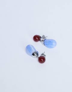 Model wearing Blaze stud earrings with drop design in red & blue