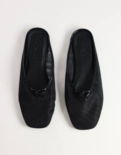 Model wearing Blythe knotted flat mule in black mesh