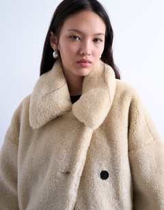 Model wearing Borg belted short car coat in cream