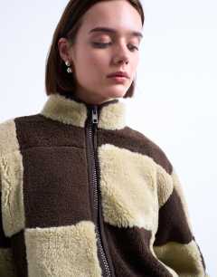 Model wearing Borg checkerboard fleece with quilted lining jacket in brown and cream