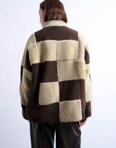 Model wearing Borg checkerboard fleece with quilted lining jacket in brown and cream