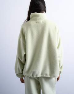 Model wearing Borg fleece funnel quarter zip co-ord in lime green