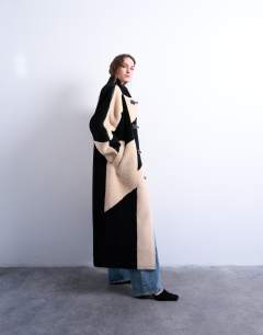 Model wearing Borg longline ovoid sleeve patchwork funnel neck coat in black