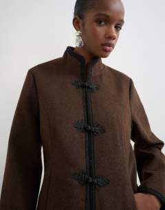 Model wearing Boucle short mandarin jacket with frogging in chocolate