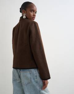 Model wearing Boucle short mandarin jacket with frogging in chocolate