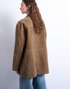 Model wearing Boxy mid length high break faux suede jacket in brown