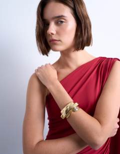 Model wearing Brena asymmetric bangle in gold