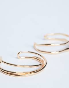 Model wearing Brooklyn 2 pack cuff bracelets in gold tone