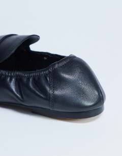 Model wearing Brooks ruched back real leather flat shoe in black