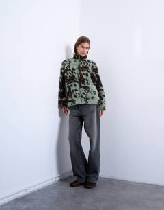 Model wearing Brown and teal cow print borg fleece jacket with contrast teal binding in multi