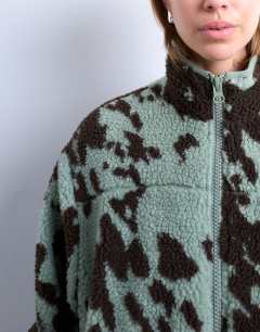 Model wearing Brown and teal cow print borg fleece jacket with contrast teal binding in multi