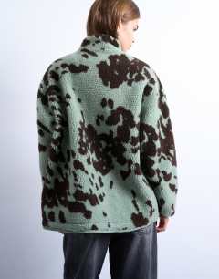 Model wearing Brown and teal cow print borg fleece jacket with contrast teal binding in multi