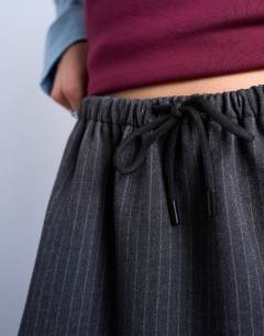 Model wearing Brushed low rise flippy mini micro skirt in charcoal pinstripe