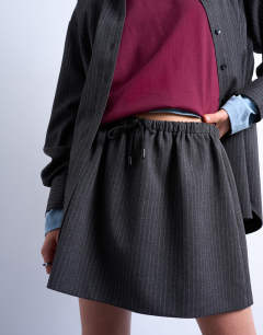 Model wearing Brushed low rise flippy mini micro skirt in charcoal pinstripe