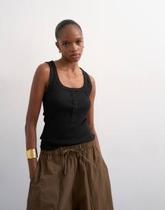 Model wearing Button rib vest in black