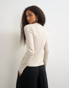 Model wearing Button through long sleeve top in oat