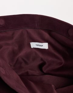 Model wearing Cam oversized real leather clutch bag in plum