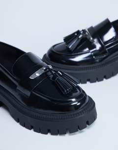 Model wearing Cameron tassel loafer with cleated sole in black